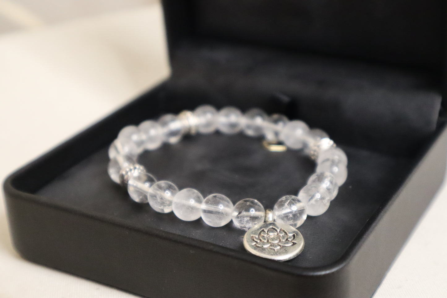 Zoom sur le bracelet en cristal de roche et son pendentif.